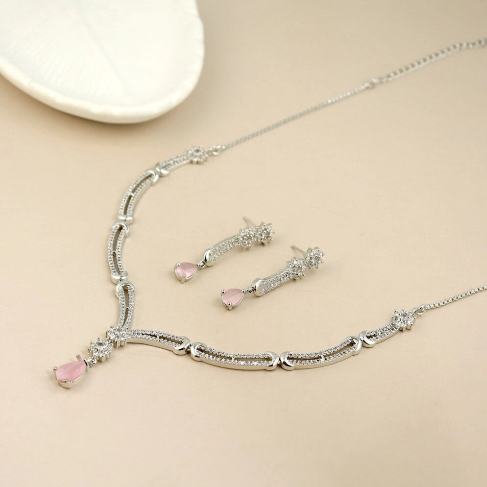 Silver necklace with pink heart pendants on a beige background