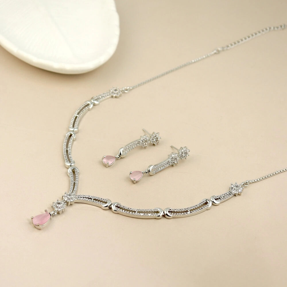 Silver necklace with pink heart pendants on a beige background