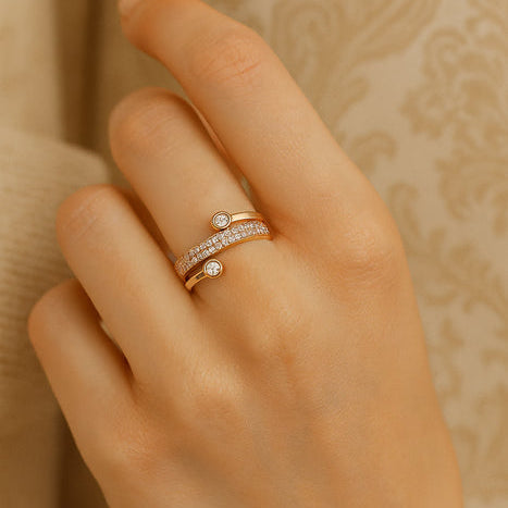 Hand wearing a rose gold ring with small diamonds on a beige background